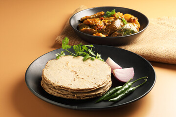 Jowar Roti or Jowar Bhakri with brinjal curry ,  a staple food in the Indian states of Maharashtra, Gujarat, and Karnataka. Sorghum is a versatile and nutrient-rich grain.