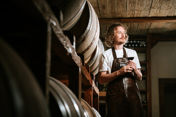 Winemaker Inspecting Red Wine in Cellar