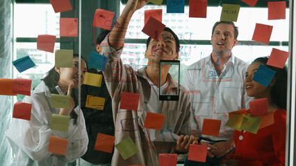 Portrait of professional business team brainstorming marketing idea by using sticky notes to share...