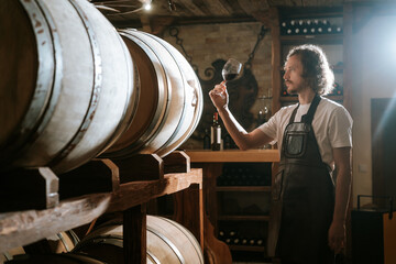 Winemaker Inspecting Red Wine in Cellar
