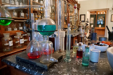 Chemistry beakers,bottles and flasks with liquids in laboratory of old pharmacy