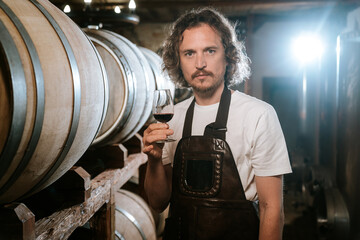 Winemaker Inspecting Red Wine in Cellar