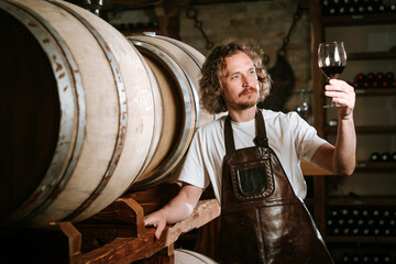 Winemaker Inspecting Red Wine in Cellar