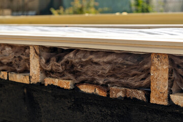 Side view of mineral wool insulation with vapor barrier in wooden house structure