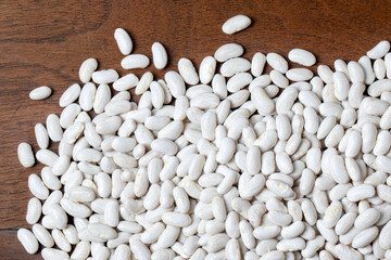 White beans on a spoon on an old wooden table