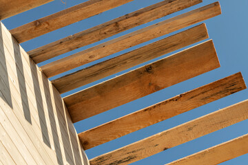 Wooden roof sheathing of a frame house against a blue sky