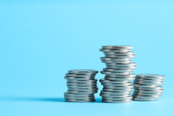 Salary concept. Stacked coins on light blue background, space for text