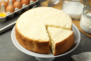 Tasty cut sponge cake on grey table