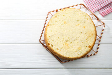 Delicious cut sponge cake on white wooden table, top view. Space for text