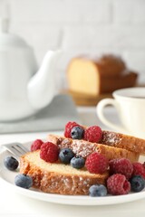 Freshly baked sponge cake, raspberries and blueberries on white wooden table, closeup