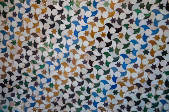 colorful pattern with flowers,stars and birds in ancient antique mosaic tile wall in Alhambra palace, Granada