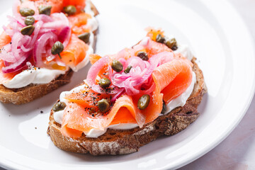 Salmon toast with cream cheese, pickled red onion and capers.