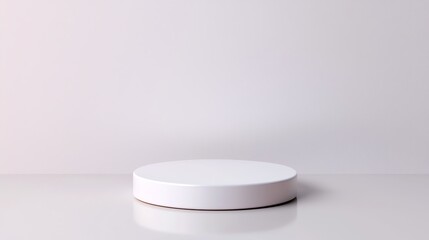 White cylindrical podium on a white background with a reflection. Ideal for product displays and presentations.
