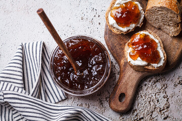 Onion jam on toast with cream cheese, gray background.