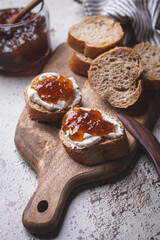 Onion jam on toast with cream cheese, gray background.