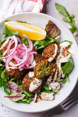 Falafel salad with tahini, red pickled onions and nuts.