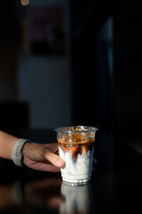 ice latte coffee in plastic glass on black table at cafe​