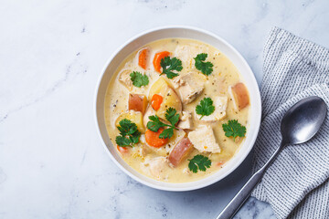 Chicken breast stew with potatoes and carrots in white bowl. Comfort food concept.