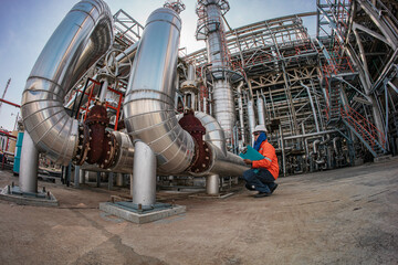 Male worker inspection at steel long pipes insulation and pipe elbow in station oil factory during refinery valve of visual check record pipeline