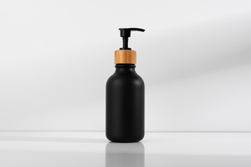 Black soap dispenser with bamboo lid, minimalist design on a soft shadows background