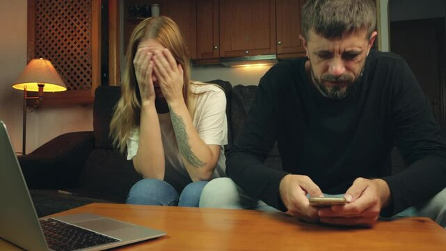 Woman struggles to connect with man engrossed in his phone. Frustration and sadness envelop space as their communication falters and disconnect grows