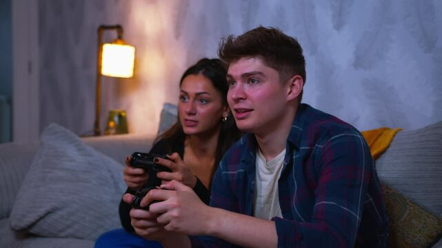 Cute couple playing video games on the sofa together and lose the game