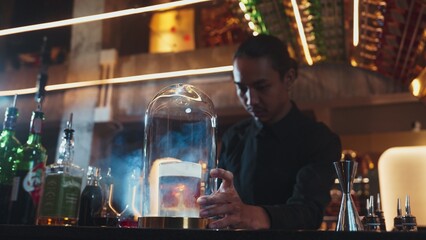 Asian bartender serving mist smoky classical mixing whiskey cocktail fantastic presentation, recommending special welcome tasty creative advertisement drink at beverage counter bar luxury. Vinosity.