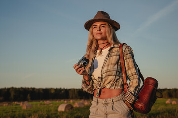 Fashionable woman with vintage photo camera  in a rural setting