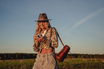 Fashionable woman with vintage photo camera  in a rural setting