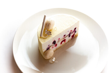 White bento cake on a white plate, isolated on white background, adorned with white chocolate ready for a special occasion.