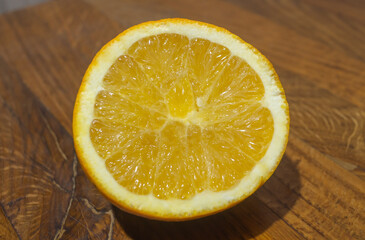 Half of an orange on a wooden table close-up