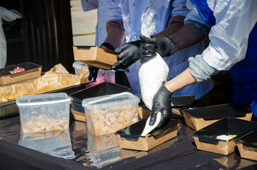 Close-up of prepared food placed in containers at an outdoor open kitchen