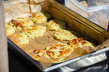 Close-up of prepared food placed in containers at an outdoor open kitchen