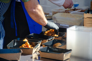 Close-up of prepared food placed in containers at an outdoor open kitchen