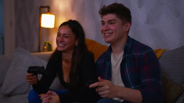 Cute couple playing video games win and celebrate together