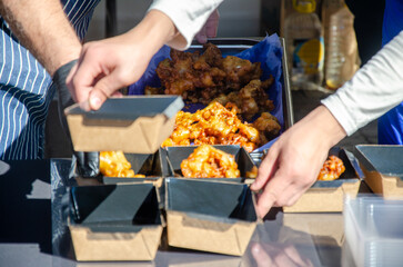 Close-up of prepared food placed in containers at an outdoor open kitchen