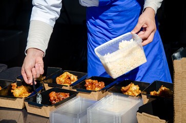 Close-up of prepared food placed in containers at an outdoor open kitchen