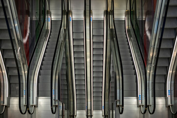 A captivating image showcasing the symmetry of modern escalators, mirroring each other in a well-lit setting, representing progress and urban architecture.