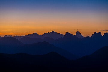 Sunset in the Dolomites beautiful landscape with mountain silhouettes and burning red light sky on the background. Sunrise and sunset in the Doloiti Alps