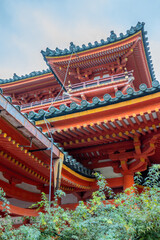 Fototapeta premium Ornate rooftops of kiyomizu-dera temple rising above lush greenery in kyoto