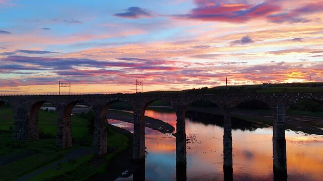 Berwick, Northumberland, UK, June 19, 2024; sunset aerial close panning clip with train of the Royal Border Bridge Viaduct, Berwick, Berwick-upon-Tweed, Northumberland, England, UK.