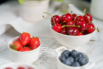 morning breakfast, juicy berries in a light plate, cherries, strawberries, raspberries