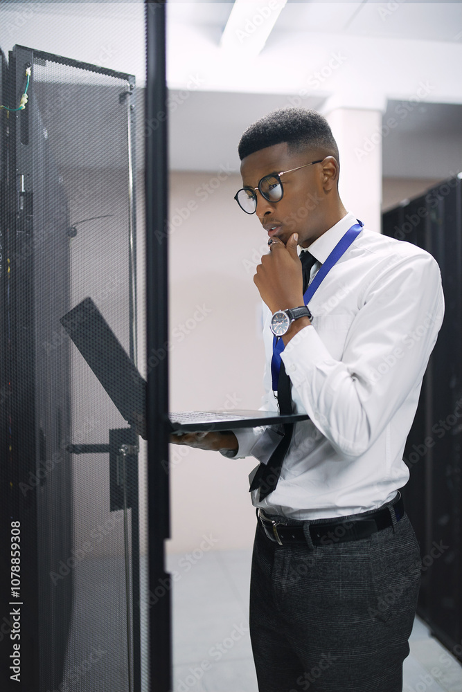 Poster Man, engineer and thinking with laptop in server room for software, hardware or network repair. Male person, IT technician or wonder with computer for technical problem solving, fix or system backup