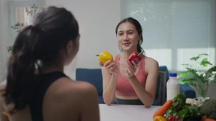 Nutritionist holding red and yellow bell peppers discusses healthy eating with a client during a consultation