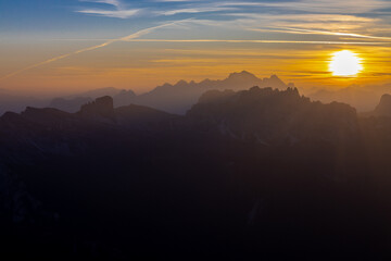 Sunset in the Dolomites beautiful landscape with mountain silhouettes and burning red light sky on the background. Sunrise and sunset in the Doloiti Alps