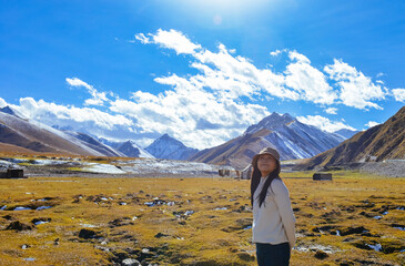 Asian woman enjoying beautiful autumn landscape of Bayanbulak Grassland along Duku Highway(Rd. G217), Korla, Xinjiang, China