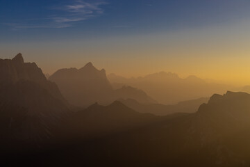 Sunset in the Dolomites beautiful landscape with mountain silhouettes and burning red light sky on the background. Sunrise and sunset in the Doloiti Alps