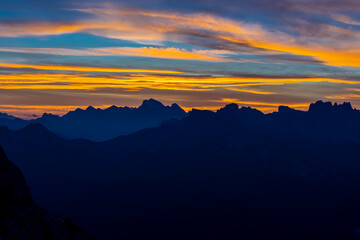 Sunset in the Dolomites beautiful landscape with mountain silhouettes and burning red light sky on the background. Sunrise and sunset in the Doloiti Alps