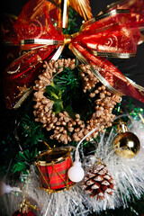 Decoration details of a Christmas tree decorated in red and gold.