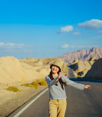 Naklejka premium Asian woman walks towards the viewer on Duku Highway (Rd. G217) at Aksu, Xinjiang, China
